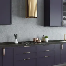 Elegancka, nowoczesna kuchnia z ciemnofioletowymi szafkami i złotymi akcentami, w tym okapem i armaturą. Na blacie kuchennym z ciemnego drewna stoją garnki, przyprawy i akcesoria kuchenne.