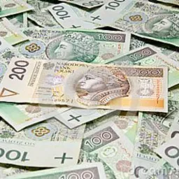 Stos banknotów polskich złotych o nominałach 100 i 200 zł, ułożonych warstwami, z widocznym portretem króla na każdym banknocie.