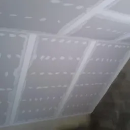 Skośny sufit z płyt gipsowo-kartonowych, widoczne łączenia wzmocnione taśmą, przygotowane do szpachlowania.