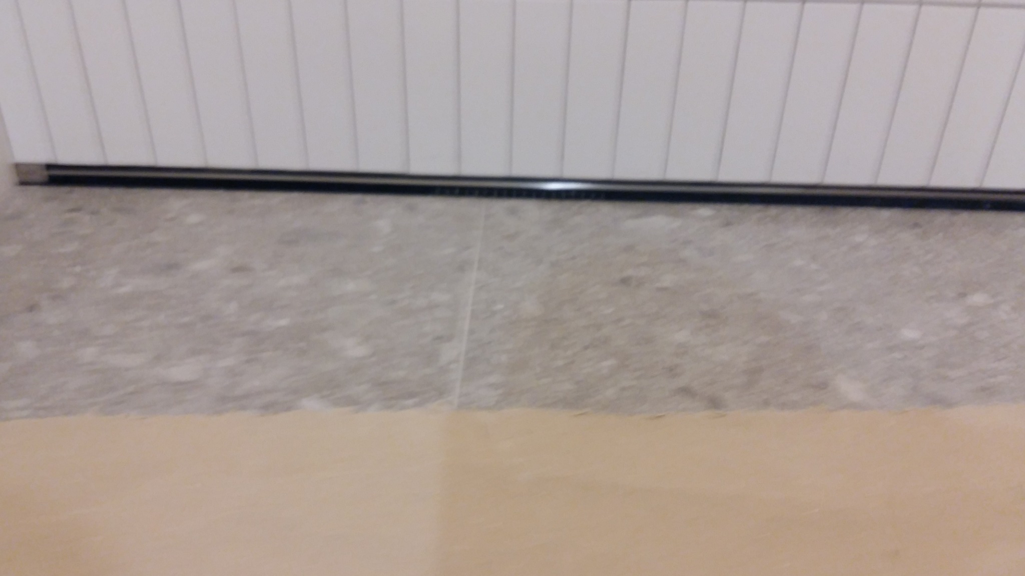 Przygotowanie podłoża pod parkiet: widoczna wylewka samopoziomująca przed ułożeniem parkietu, z fragmentem ściany z listwą przypodłogową w tle.