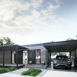 Nowoczesny parterowy dom z szarej deski z zadaszonym miejscem parkingowym i pergolą, otoczony zielenią.