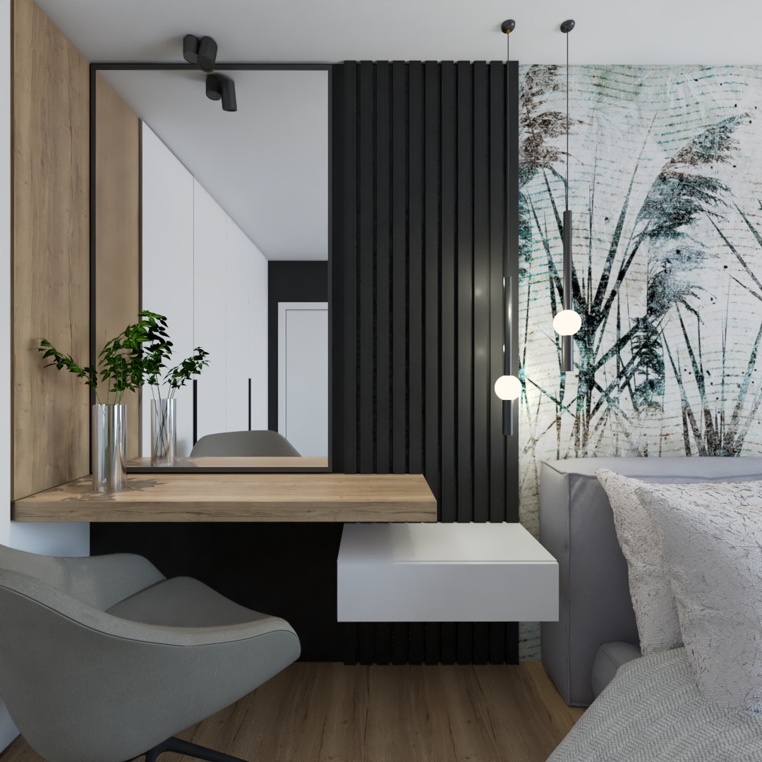 Nowoczesna toaletka z dużym lustrem, drewnianym blatem, szarą tapicerowaną pufą i dekoracyjną ścianą z motywem roślinnym, oświetlona wiszącymi lampami.