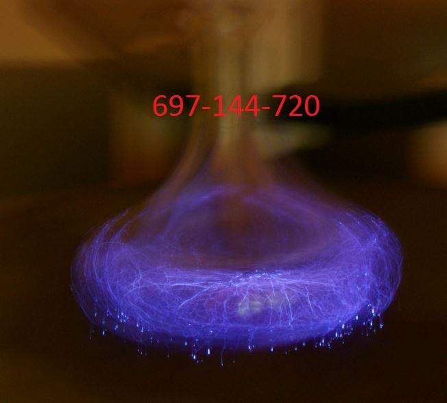 Nietypowe ujęcie wyładowań elektrycznych w szklanej bańce, ukazujące fioletowe iskry i rozbłyski.