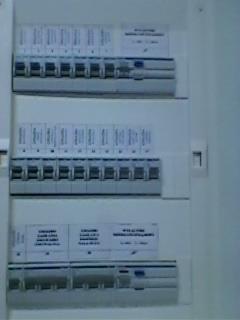 Rozdzielnica elektryczna z zainstalowanymi bezpiecznikami automatycznymi i opisami, widok z bliska.