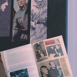 JW Projekt - Strona z otwartego czasopisma przedstawiająca zdjęcia aktorów w kostiumach z filmu wojennego, w tym zbliżenia twarzy w mundurach i sceny akcji, oraz artykuły o reżyserach.