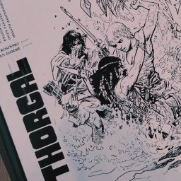 JW Projekt - Ręcznie rysowany czarno-biały plakat z ilustracją postaci Thorgala w dynamicznej scenie walki w dżungli, widoczne daty wydania i nazwiska twórców.