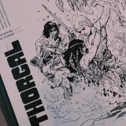 Ręcznie rysowany czarno-biały plakat z ilustracją postaci Thorgala w dynamicznej scenie walki w dżungli, widoczne daty wydania i nazwiska tw&oacute;rc&oacute;w.