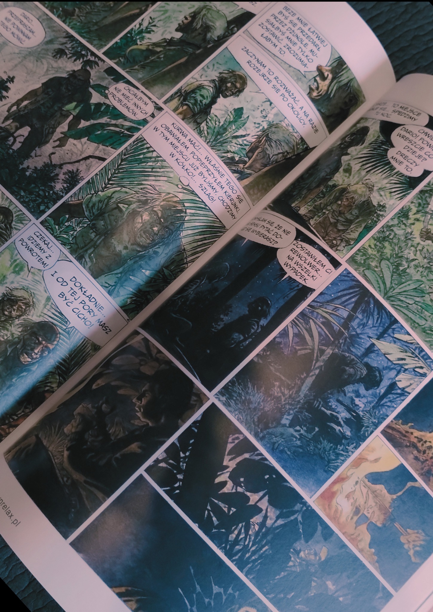 Otwarty komiks z ilustracjami w stylu akwareli przedstawiającymi sceny w dżungli i żołnierzy, z dymkami dialogowymi w języku polskim.