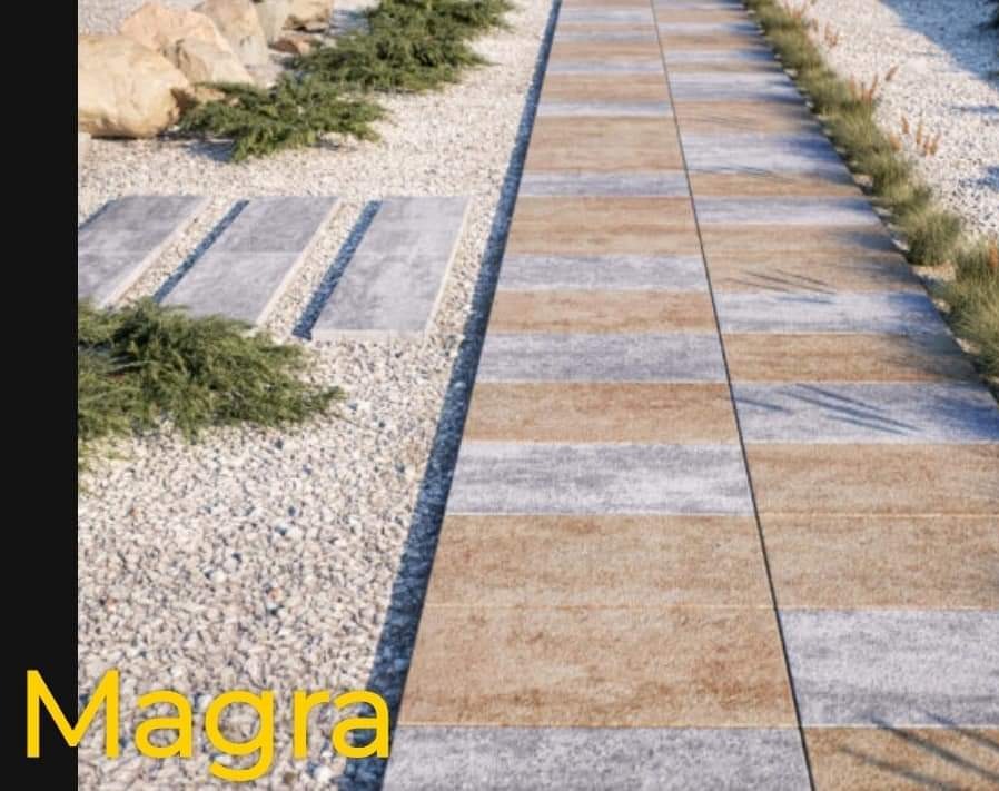 Ścieżka z ułożonych naprzemiennie szarych i beżowych płyt, otoczona drobnym żwirem i niską zielenią, z dodatkowymi płytami w żwirze po lewej stronie.