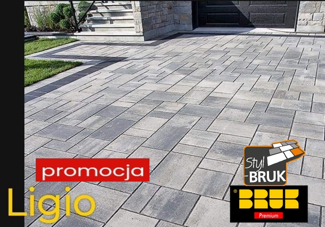 Ułożona szara nawierzchnia z prostokątnych elementów, z widocznym fragmentem schodów wejściowych do budynku i trawnikiem, z naniesionymi grafikami promocyjnymi i logotypami producenta.