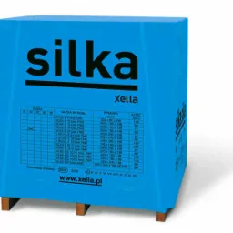 Paleta z niebieskim opakowaniem bloczków Silka E24 z widoczną specyfikacją techniczną, umieszczona na drewnianych paletach, na białym tle.
