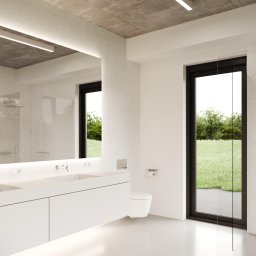 Design Studio Jacek Łuczak - Minimalistyczna łazienka z betonowym sufitem, białymi meblami i dużym oknem z widokiem na zieleń. Nowoczesny design z podświetleniem LED i szklaną kabiną prysznicową.