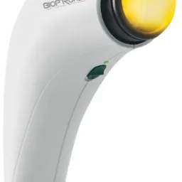 Lampa Bioptron do światłoterapii, widoczny włącznik i logo na białej obudowie, z żółtym światłem.