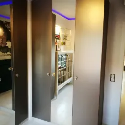 Szafa wnękowa z lustrzanymi drzwiami w szarym kolorze, z dekoracyjnymi kryształowymi uchwytami, oświetlenie LED w suficie