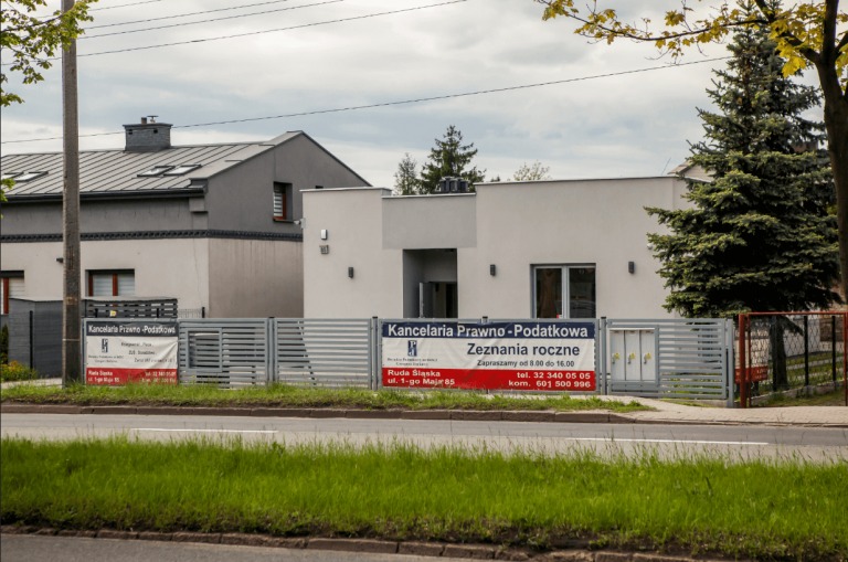 Budynek Kancelarii Prawno-Podatkowej w Rudzie Śląskiej z banerem reklamowym dotyczącym zeznań rocznych, widoczny zza ulicy.