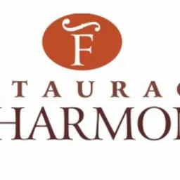 Logo restauracji Filharmonia z brązowym owalem zawierającym literę F, umieszczone nad nazwą restauracji zapisaną brązowymi literami.