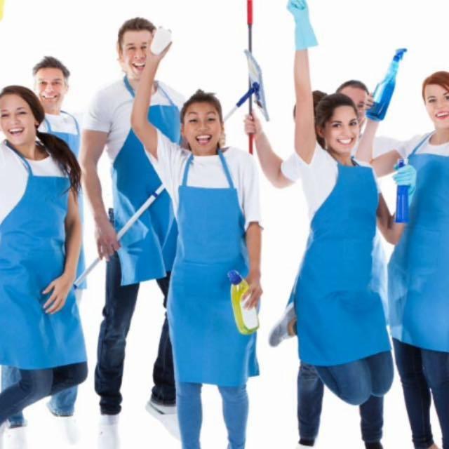 Zespół sprzątający w niebieskich fartuchach, pozujący z mopem, ściereczką i środkami czystości, wyrażający radość i entuzjazm na białym tle.
