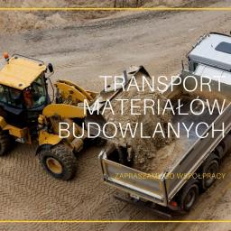 Deliś Transport - Żółta ładowarka czołowa i ciężarówka podczas transportu materiałów budowlanych w Grodzisku Mazowieckim.