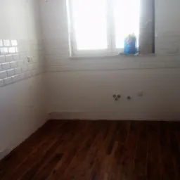 Wnętrze łazienki po remoncie, z białymi płytkami typu metro na ścianie, drewnopodobną podłogą i grzejnikiem panelowym.