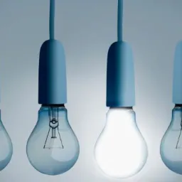 Cztery żarówki w odcieniach niebieskiego, jedna z nich świeci intensywnym białym światłem, pozostałe wyłączone.