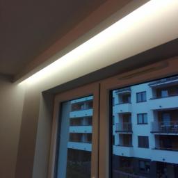 Kamil Kotusiński - Wnęka okienna z zamontowanym oświetleniem LED, widok na budynek mieszkalny za oknem.