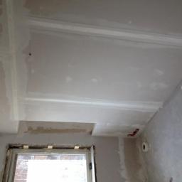 MalHus Szpachlowanie Natryskowe, Malowanie, GK Zabudowy,Poddasza - Ściana i sufit w trakcie prac wykończeniowych, widoczne ślady szpachlowania i gładzi, częściowo zamaskowane okno.