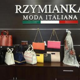 Rzymianka - Ekspozycja torebek i akcesoriów w butiku z włoską modą, widoczne logo 'RZYMIANKA Moda Italiana' z motywem włoskiej flagi.