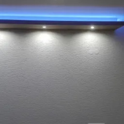 Ściana w pokoju pomalowana na szaro z widoczną strukturą, podświetlona niebieskim światłem LED z sufitu, z zamontowanymi punktowymi lampami halogenowymi i grzejnikiem pod ścianą.