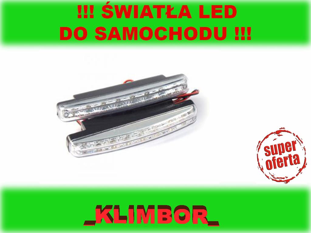 Dwa samochodowe światła LED do jazdy dziennej, z widocznymi przewodami, na białym tle z zielonymi napisami reklamowymi i czerwonym stemplem 'Super Oferta'.