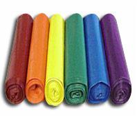 Rząd kolorowych worków na śmieci zwiniętych w rolki, ułożonych obok siebie: czerwony, pomarańczowy, żółty, zielony, niebieski, fioletowy. Widoczne cienie rzucane przez worki.