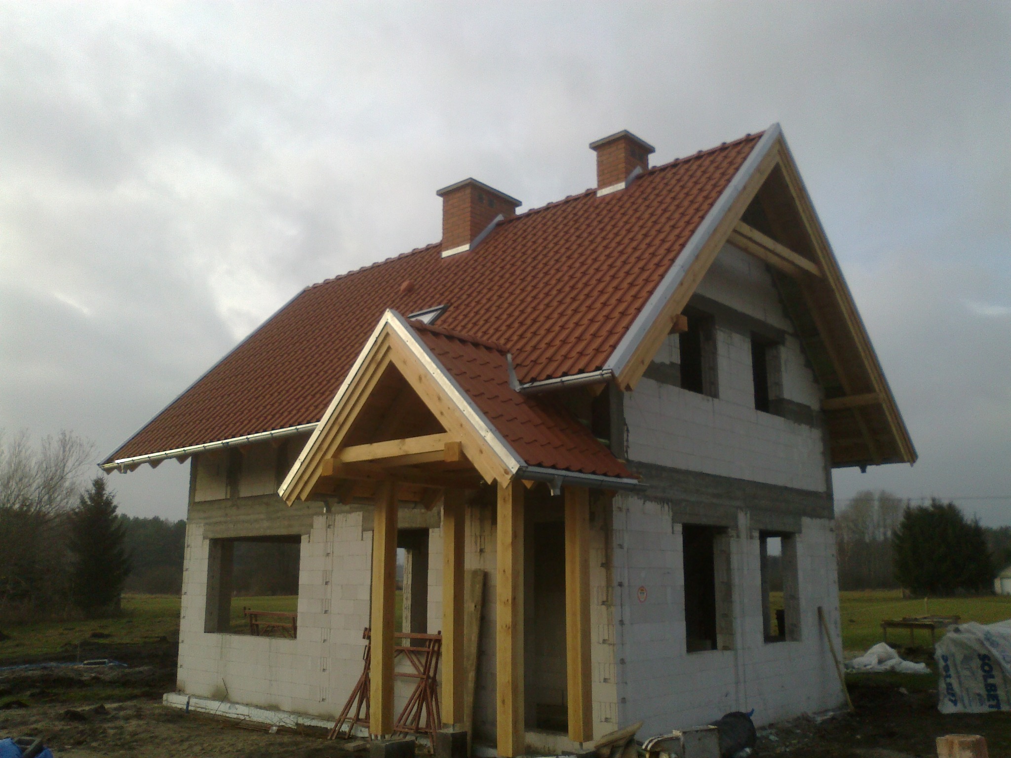 Budynek mieszkalny jednorodzinny murowany, dachówka ceramiczna, elementy drewniane szlifowane i impregnowane bezbarwnie.