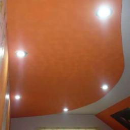 firma jednoosobowa - Pomarańczowy, podwieszany sufit z wbudowanymi punktowymi lampami, ściana z tapetą w dziecięce wzory, fragment dekoru ściennego w rogu.