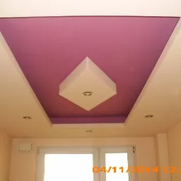 Dekoracyjny sufit podwieszany z fioletowym wnęką i centralnym elementem w kształcie rombu z oświetleniem punktowym