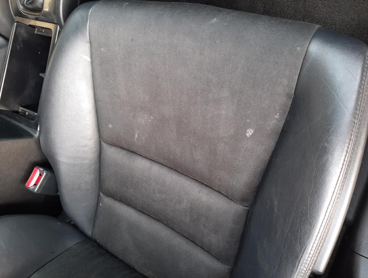 Czarne, zabrudzone siedzenie samochodowe z plamami, widoczne z bliska w Kostrzynie.