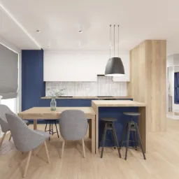 Nowoczesny salon z kuchnią: drewniany st&oacute;ł z szarymi krzesłami, wyspa kuchenna z hokerami, białe szafki z niebieskimi akcentami, marmurowe płytki na ścianie, wisząca lampa i drewniana podłoga.