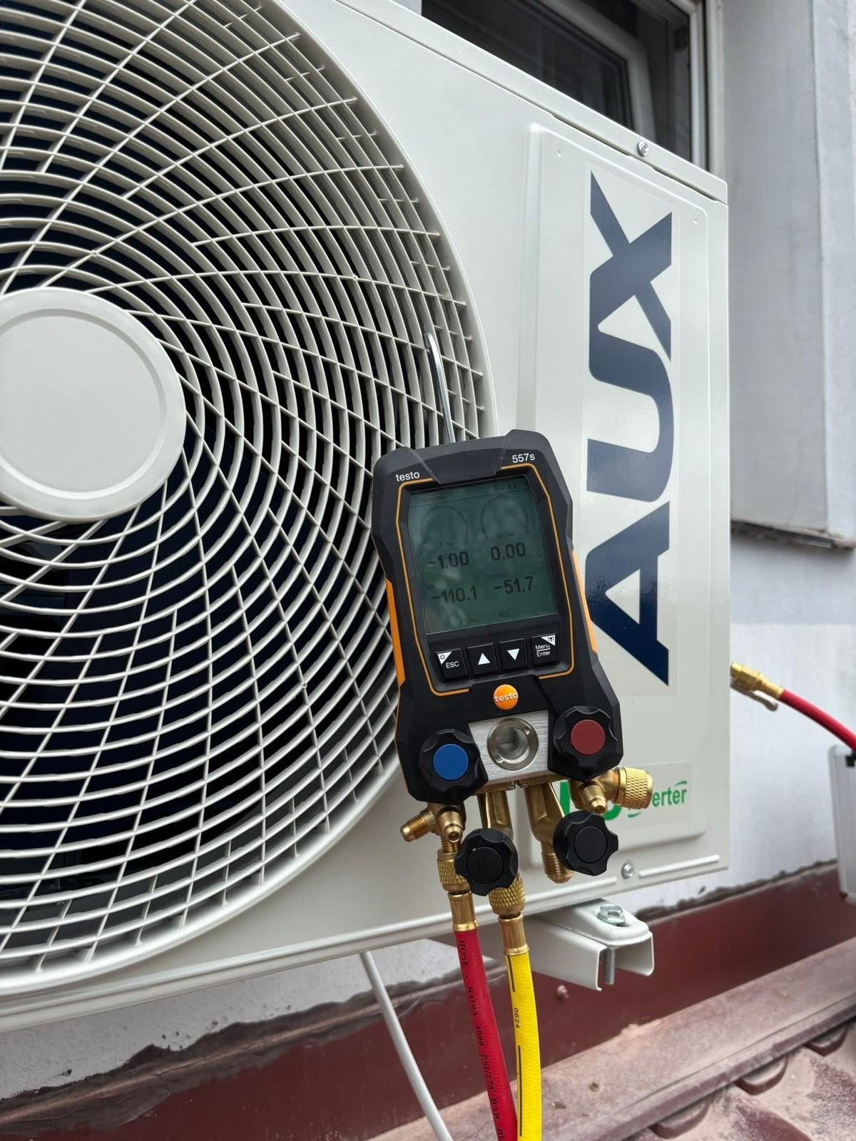 Serwis klimatyzacji: Manometr cyfrowy Testo 557s podłączony do jednostki zewnętrznej klimatyzatora AUX, pomiar ciśnienia czynnika chłodniczego.