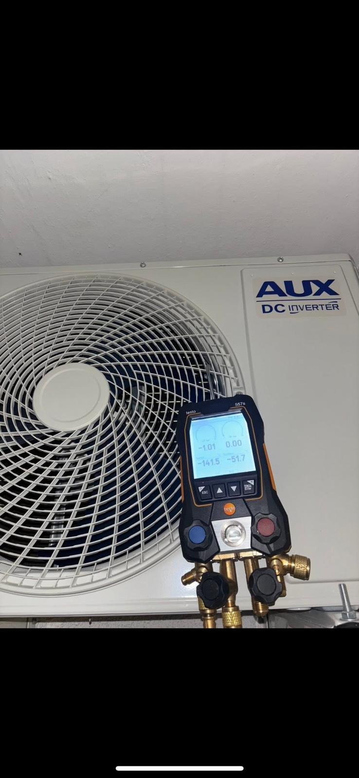 Biała klimatyzacja AUX DC Inverter z podłączonym cyfrowym manometrem Testo 557s, wskazującym wartości ciśnienia podczas serwisu.