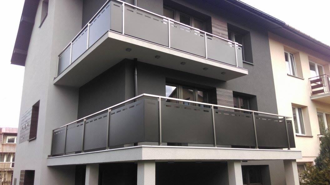 Nowoczesne balustrady balkonowe ze stali nierdzewnej i matowego szkła na dwóch poziomach budynku mieszkalnego.
