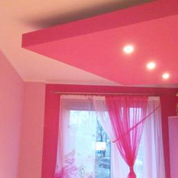 Renomex - Różowy pokój dziecięcy w Tychach po malowaniu, z podwieszanym sufitem z oświetleniem punktowym i zasłonami w oknie.