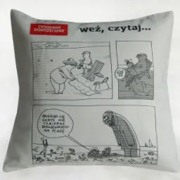 Poduszka z nadrukowanym czarno-białym komiksem z motywem plażowym i napisem 'Tygodnik Powszechny weź, czytaj...' oraz dymkiem z tekstem 'Prosiłam Cię żebyś nie zabierał Dostojewskiego na plażę.'