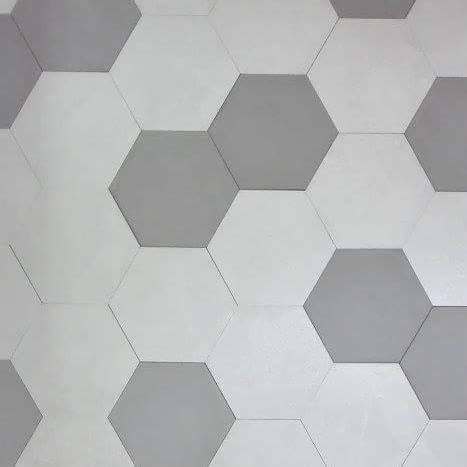 Świeżo pomalowana ściana z wzorem heksagonów w odcieniach szarości i bieli, widoczne delikatne niedoskonałości łączeń.