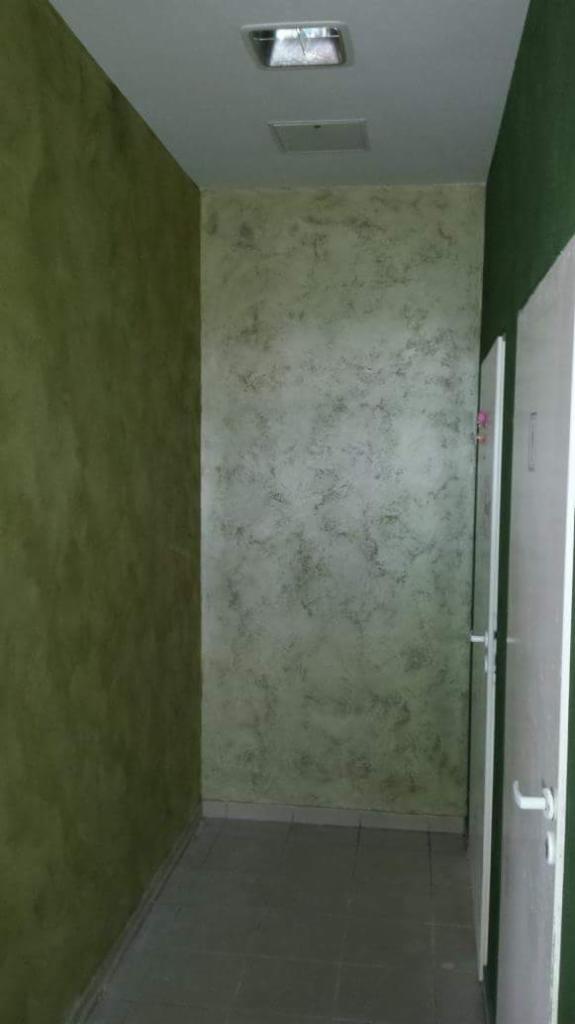 Korytarz w Sobolewie z wykończonymi ścianami w odcieniach zieleni i szarości, z efektem dekoracyjnym przypominającym marmur, widoczna lampa sufitowa i fragment drzwi.