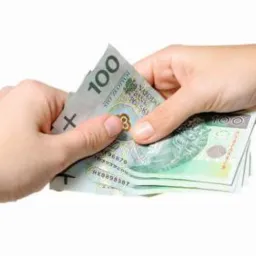 Dwie dłonie przekazują sobie plik banknotów o nominale 100 złotych na białym tle.