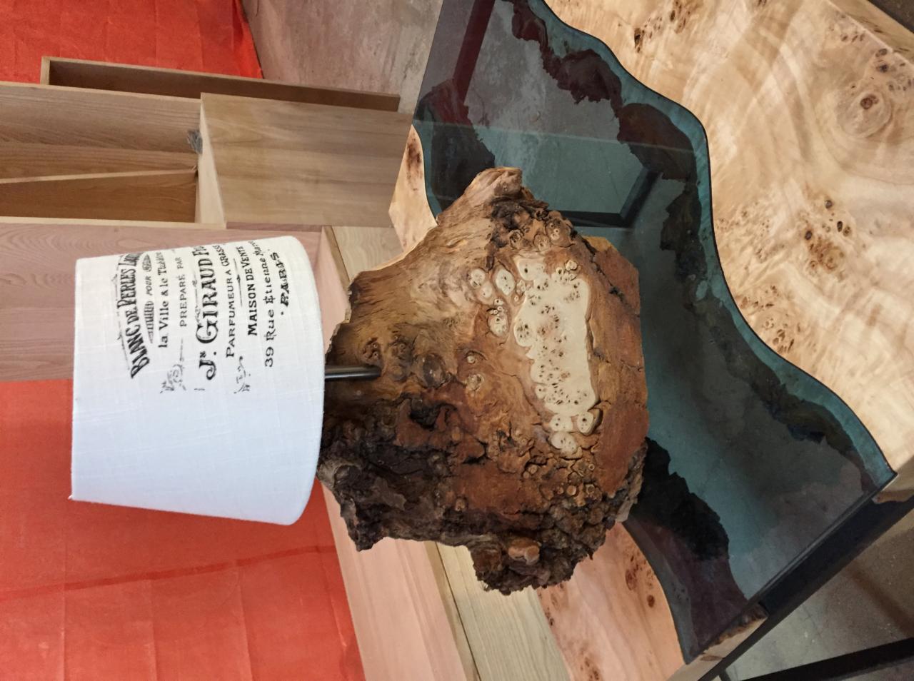 Fragment blatu z drewna z żywicą epoksydową, obok lampa z abażurem z nadrukiem w stylu retro, prezentacja materiałów do wykonania blatu.