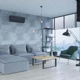 Nowoczesny salon z szarą sofą modułową, drewnianym stolikiem kawowym i klimatyzatorem INOVA zamontowanym na szarej ścianie o betonowej fakturze, widok na miasto przez panoramiczne okno.