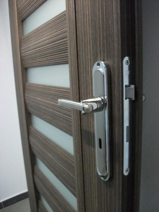 Nowoczesne drzwi wewnętrzne z poziomymi paskami z matowego szkła, brązowe drewno i chromowana klamka z zamkiem.