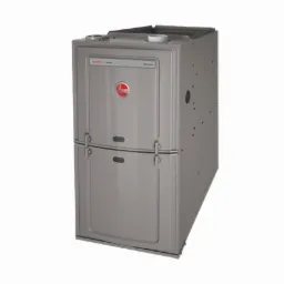 Szara, metalowa obudowa centrali wentylacyjnej Rheem Classic Pro Series na białym tle, widoczny okrągły otwór z boku i logo producenta na froncie.