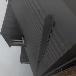 Szary dach z blachy trapezowej z oknem dachowym i obróbką blacharską, widok z dołu w Gdańsku.