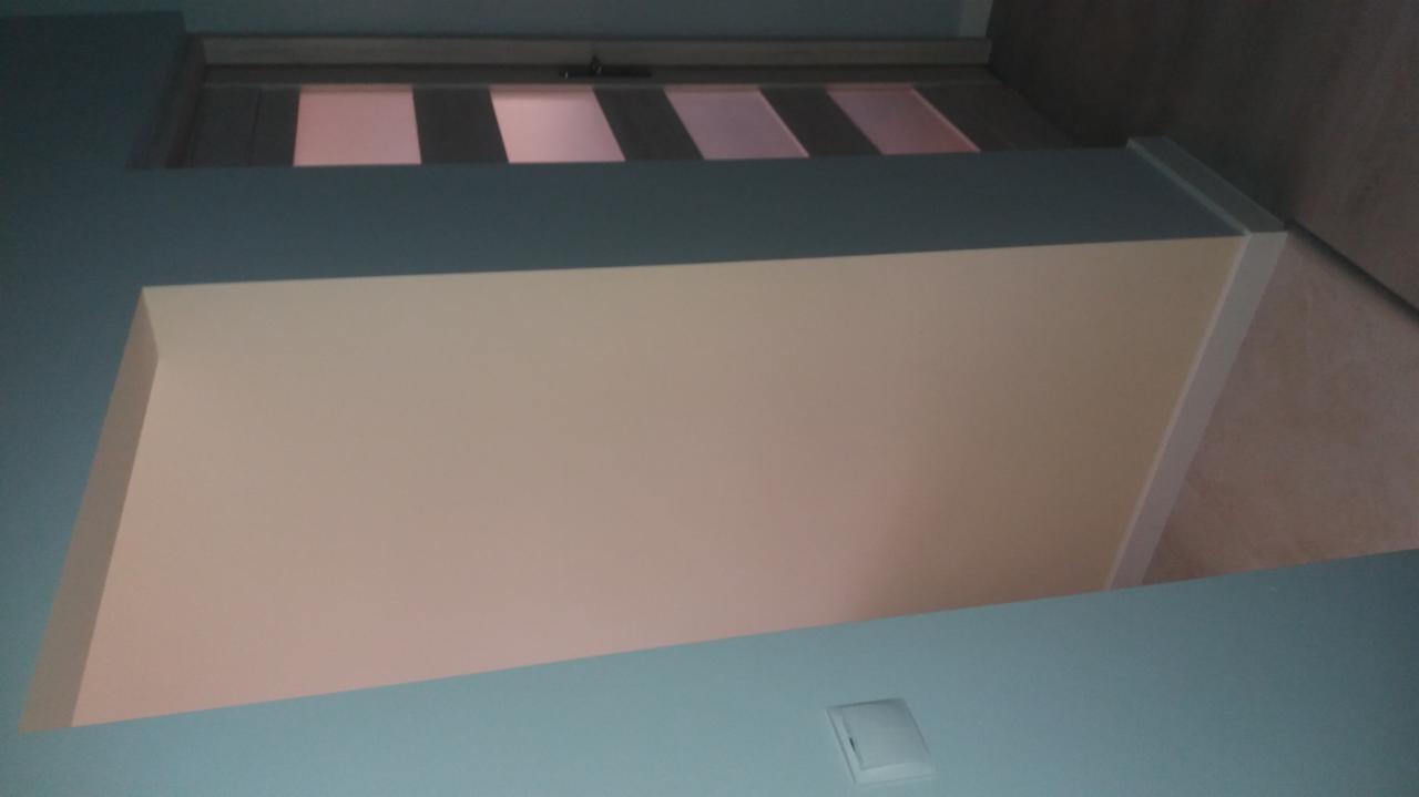 Świeżo pomalowane ściany w odcieniach błękitu i beżu, widok z dołu na sufit z fragmentem drzwi z szybami.