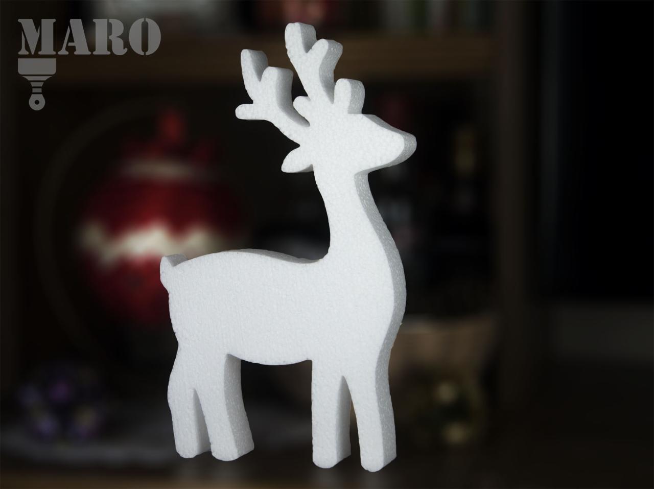 Biała, styropianowa figurka renifera na tle dekoracji świątecznych, z widocznym logo firmy MARO.